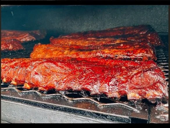 Racks of dry-rubbed baby back ribs with a deep mahogany glaze