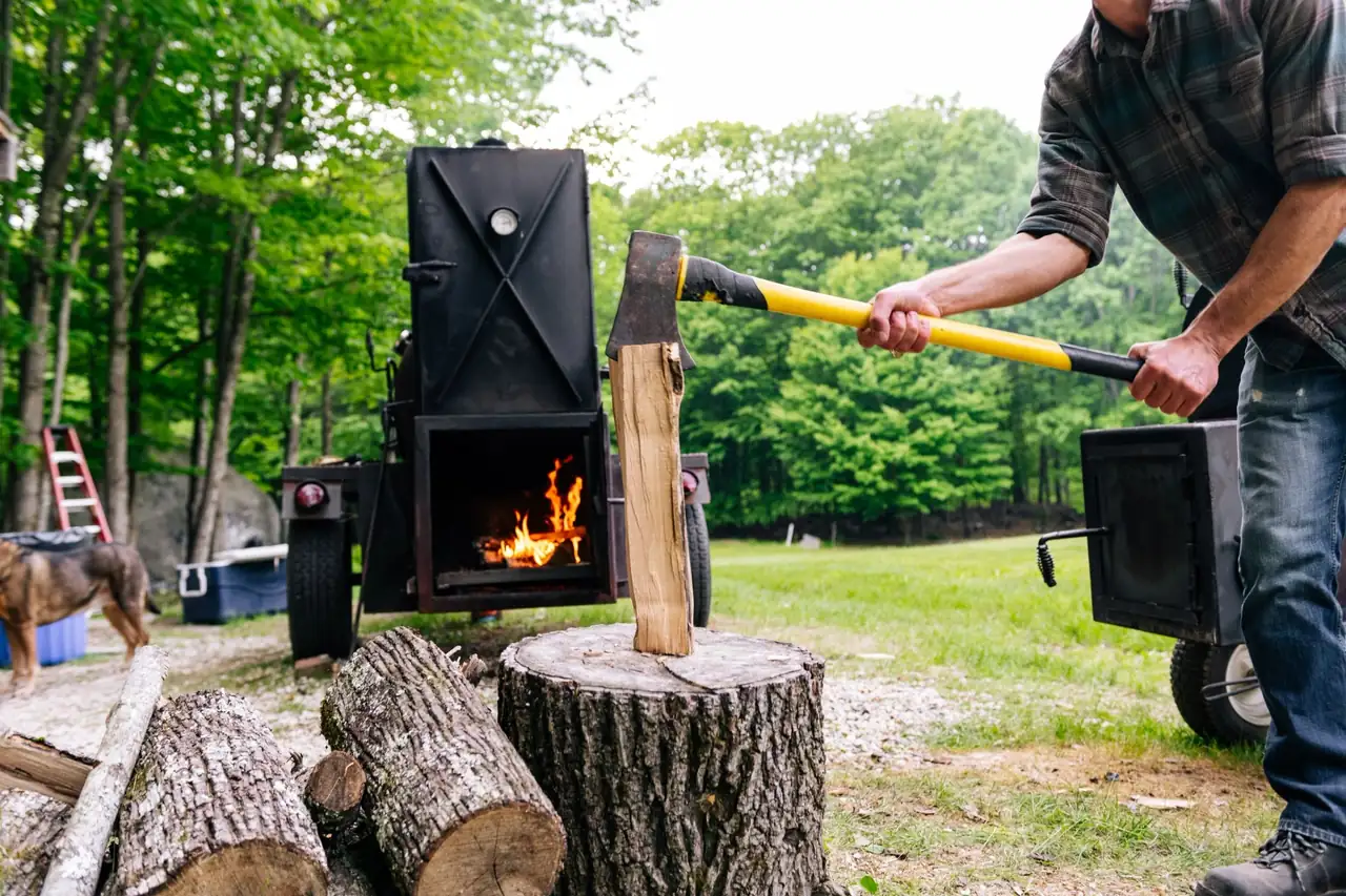 Splitting hickory by the smoker firebox, flames going, at the family farm